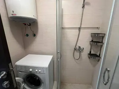 a shower stall with a washing machine in a bathroom at Coastera Group Cascadas 8 in Sunny Beach