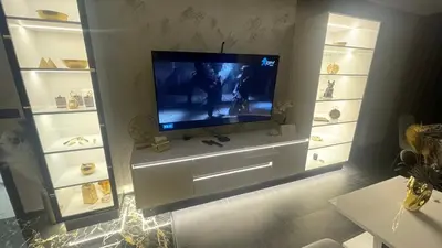 a living room with a flat screen tv on a wall at Golden Pearl of Luxury - Burgas in Burgas City