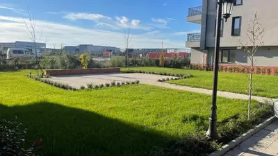 a grassy yard next to a building with a street light at Golden Pearl of Luxury - Burgas in Burgas City