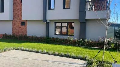 a white house with a grass yard and a building at Golden Pearl of Luxury - Burgas in Burgas City