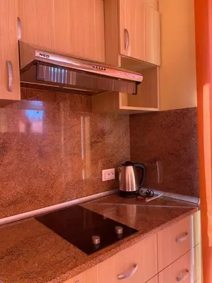 a kitchen with wooden cabinets and a stove top oven at Sunny Home 2 in Sunny Beach
