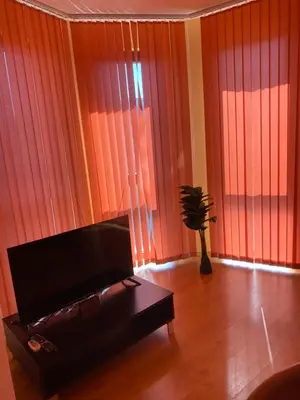 a living room with orange curtains and a couch at Sunny Home 2 in Sunny Beach