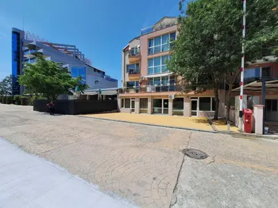 a person walking down a street next to a building at Бобс апартаменти 2 in Kiten