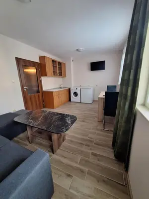 a living room with a couch and a table and a kitchen at Бобс апартаменти 2 in Kiten