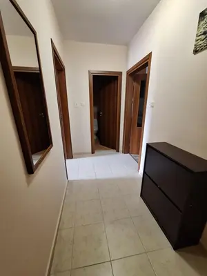 a hallway with doors and a dresser in a room at Бобс апартаменти 2 in Kiten