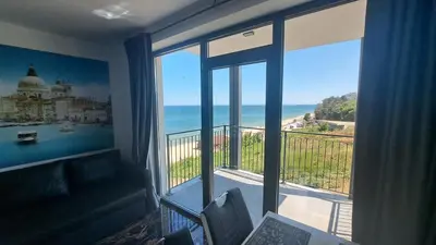 a room with a balcony with a view of the ocean at LUXE 1 Venezia Suite in Obzor