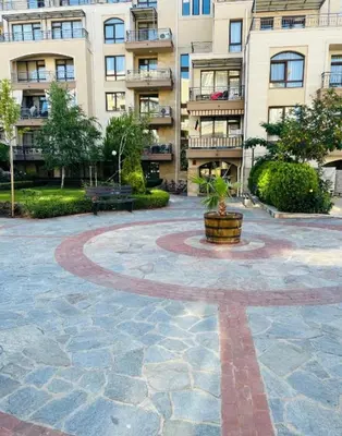 a courtyard in front of a building with a potted plant at Sorrento Sole Mare Sveti Vlas in Sveti Vlas