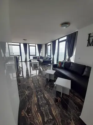 a living room with a black couch and tables at Luxe 1 Monte Carlo Suite in Obzor