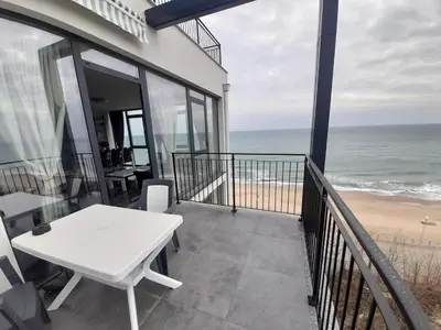 a balcony with a table and a view of the beach at Luxe 1 Monte Carlo Suite in Obzor
