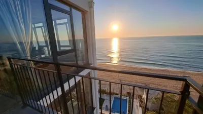 a balcony with a view of the beach and the sunrise at Luxe 1 Monte Carlo Suite in Obzor