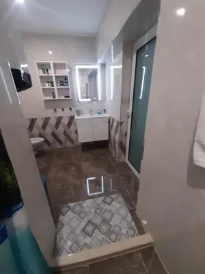 a bathroom with a shower and a tiled floor at Luxe 1 Monte Carlo Suite in Obzor