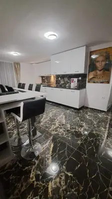 a living room with a marble floor and a kitchen at Luxe 1 Dubai Penthouse in Obzor