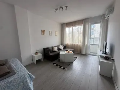 a living room with a couch and a television at Ssenyange Sea Garden Apartment in Varna City