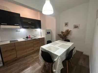 a kitchen with a table and a kitchen with a sink at Ssenyange Sea Garden Apartment in Varna City