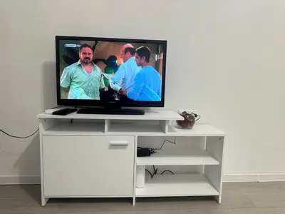 a flat screen tv sitting on a white stand at Ssenyange Sea Garden Apartment in Varna City
