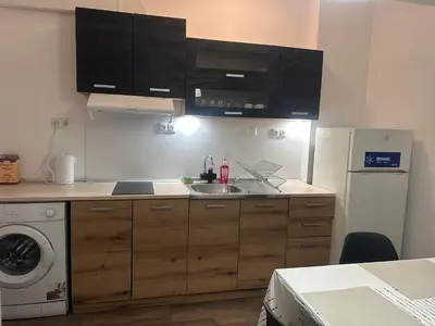 a kitchen with a sink and a refrigerator at Ssenyange Sea Garden Apartment in Varna City