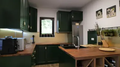a kitchen with green cabinets and a wooden counter top at Вила Лонгоз