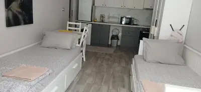 a small room with two beds and a kitchen at Студио за двама в центъра на град Бургас in Burgas City