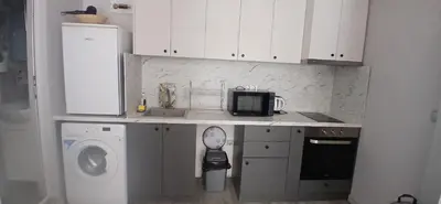 a kitchen with a washing machine and a washer at Студио за двама в центъра на град Бургас in Burgas City