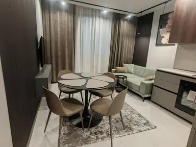 a kitchen and living room with a table and chairs at Апартамент Александровска in Burgas City