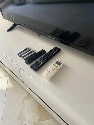 two remote controls and a tv on a table at Апартамент в затворен комплекс Артур гр Свети Влас in Sveti Vlas