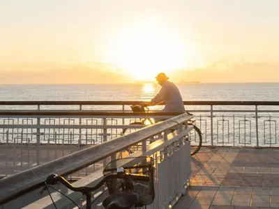 a man riding a bike on a pier with the ocean at Sanders Solemare By the Sea - Close to Sunny Beach and Nessebar in Aheloy