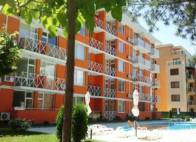 a large apartment building with a swimming pool in front of it at Seaview apartment with garden & pool in Sunny Beach