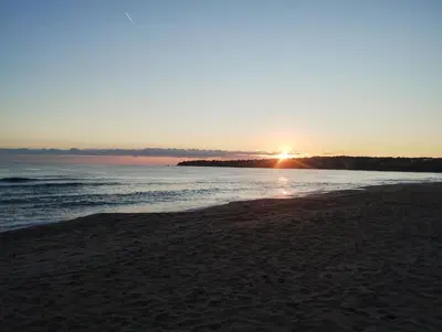 a sunset on a beach with the ocean at Рай in Burgas City