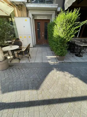 a patio with tables and chairs in front of a building at Velaria Centre Apartment in Burgas City