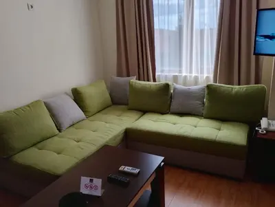 a living room with a green couch and a table at Garden of Eden - M303 Rey&Mar Apartaments in Sveti Vlas