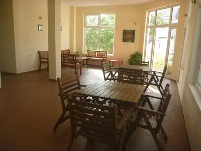 a dining room with tables and chairs and windows at Mechta Family Hotel in Obzor