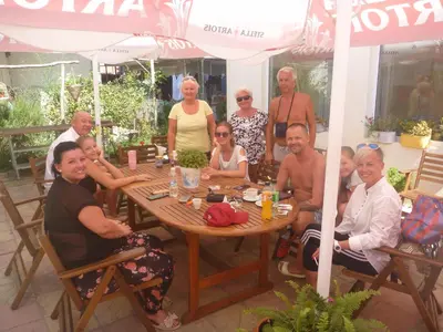 a group of people sitting around a wooden table at Mechta Family Hotel in Obzor
