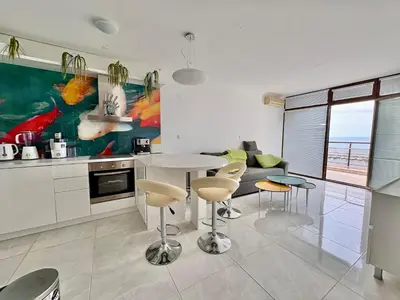a kitchen with a table and chairs in a room at Sveti Vlas Marina Beach Apartment - Diamond Apart Complex in Sveti Vlas