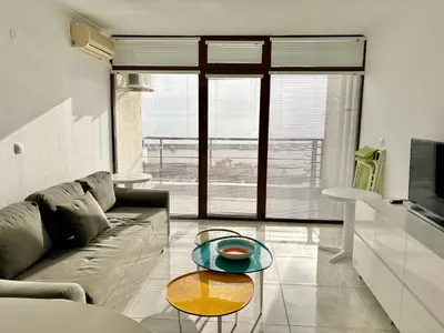 a living room with a couch and a glass table at Sveti Vlas Marina Beach Apartment - Diamond Apart Complex in Sveti Vlas