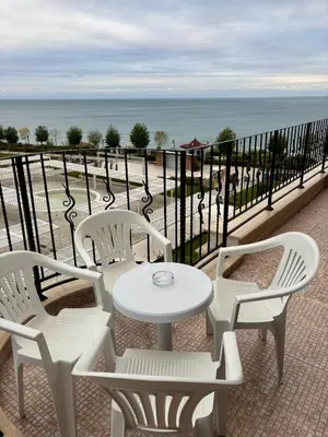 a white table and chairs on a balcony with the ocean at Luxury in Sveti Vlas