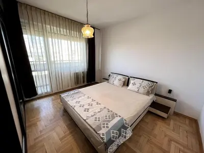 a bedroom with a bed and a large window at Home for you, 2-bedroom apartment in Burgas City