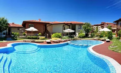 a swimming pool with chairs and umbrellas in front of a house at Garden of Eden - Panorama C15 Rey&Mar in Sveti Vlas