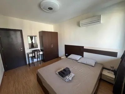 a bedroom with a bed with a bag on it at Camping Gradina Sunny Bay Appartment in Chernomorets