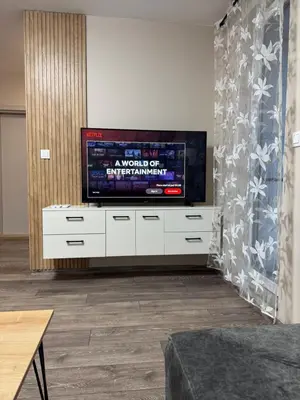 a living room with a flat screen tv on a white cabinet at Danny Apartment Welcomes You in Burgas City