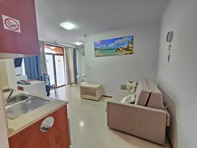 a small living room with a couch and a kitchen at PALAZZO FAMILY SUITE Sunny beach in Sunny Beach