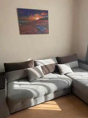 a couch in a living room with a painting on the wall at Sunny day 5 in Tŭnkovo
