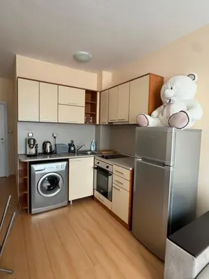 a kitchen with a refrigerator and a teddy bear on top of it at Sunny day 5 in Tŭnkovo