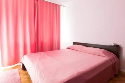 a bedroom with a bed and a window with red curtains at Relax in Lazur - Georgi Baev Str in Burgas City