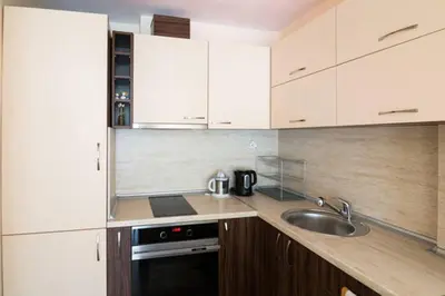 a kitchen with white cabinets and a sink at Relax in Lazur - Georgi Baev Str in Burgas City