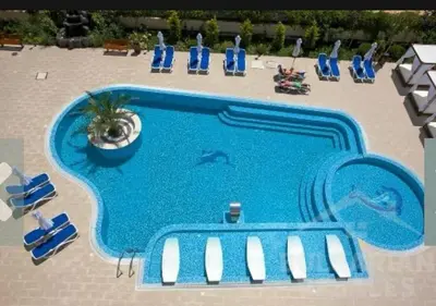 an overhead view of a large swimming pool with chairs and people at Villa Valencja Apartments in Sunny Beach