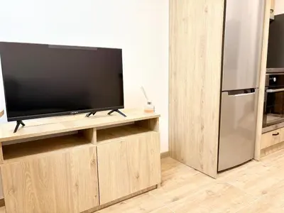 a flat screen tv sitting on top of a wooden entertainment center at Skyline Loft in Varna City