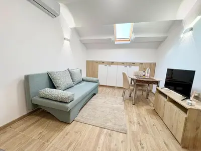a living room with a blue couch and a table at Skyline Loft in Varna City