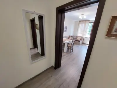a hallway with a mirror and a dining room at Апартаменти Делукс 2 in Burgas City