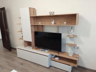 a living room with a tv on a shelf at Апартаменти Делукс 2 in Burgas City