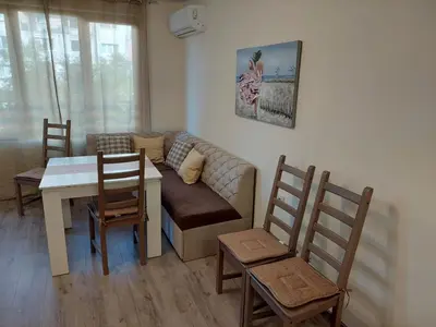 a living room with a couch and a table and chairs at Апартаменти Делукс 2 in Burgas City
